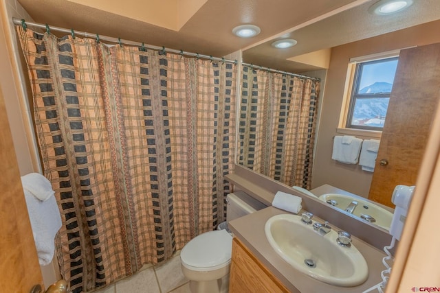 bathroom with tile patterned flooring, vanity, and toilet