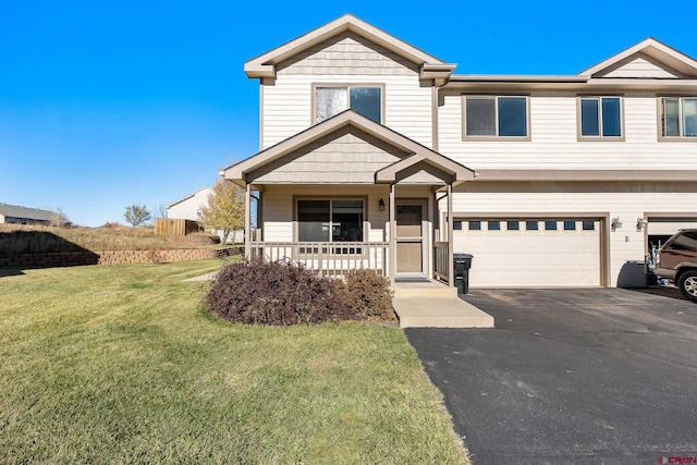 view of front of property with covered porch, a garage, and a front lawn