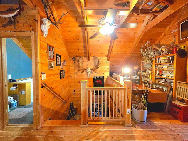 interior space with vaulted ceiling with beams, wood-type flooring, wood ceiling, and wooden walls