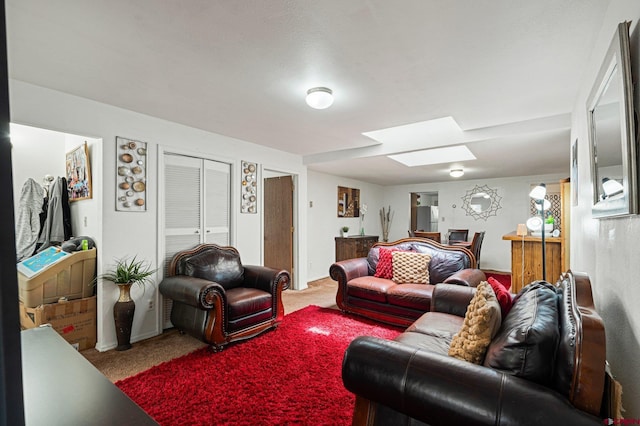 carpeted living room featuring a skylight