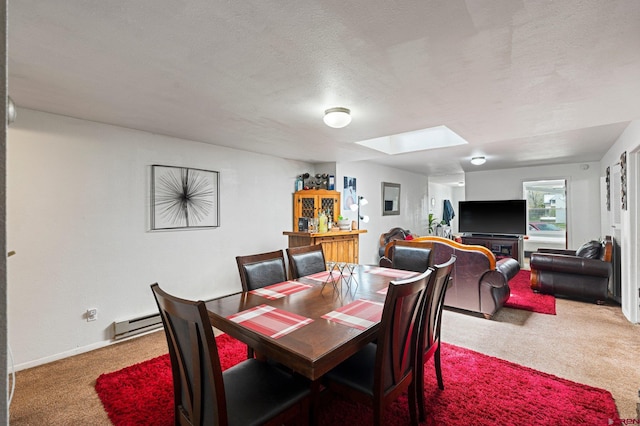 dining area featuring a skylight, carpet floors, a baseboard radiator, and a textured ceiling