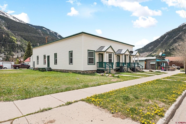 view of front facade with a mountain view and a front lawn