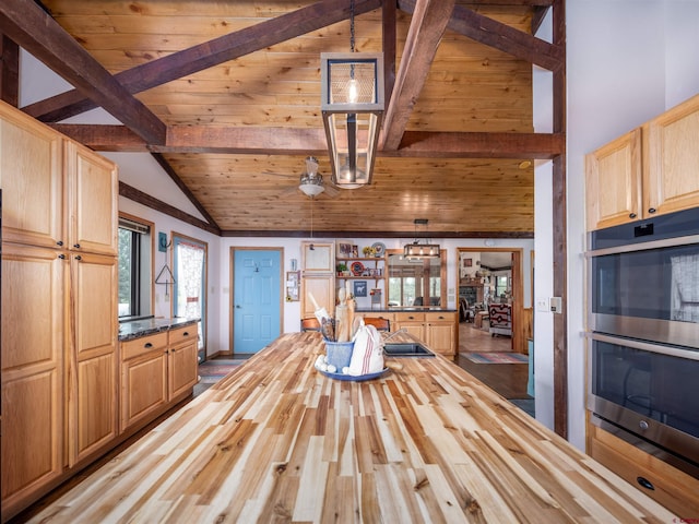 interior space with stainless steel double oven, hanging light fixtures, wood counters, beamed ceiling, and hardwood / wood-style floors