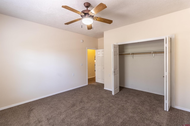 unfurnished bedroom featuring a textured ceiling, a closet, dark carpet, and ceiling fan