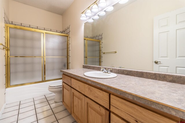 full bathroom with tile patterned flooring, vanity, toilet, and combined bath / shower with glass door