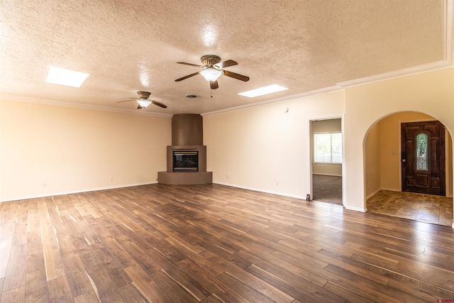 unfurnished living room with ornamental molding, a textured ceiling, and dark wood-type flooring