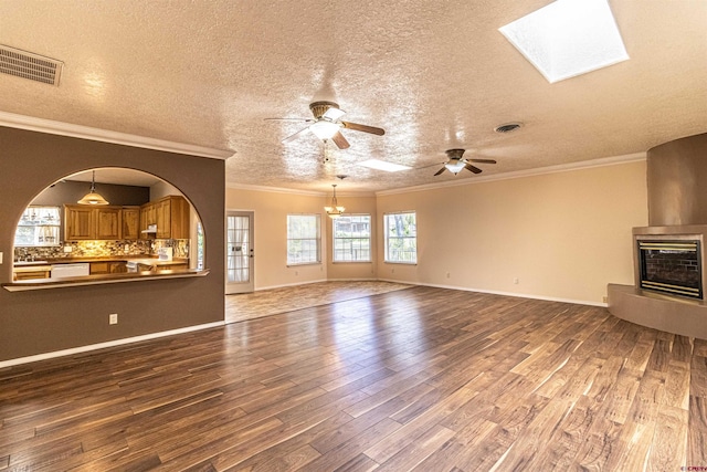 unfurnished living room featuring crown molding, hardwood / wood-style floors, a textured ceiling, a fireplace, and ceiling fan with notable chandelier