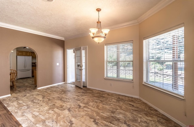 empty room featuring a notable chandelier, plenty of natural light, crown molding, and a textured ceiling