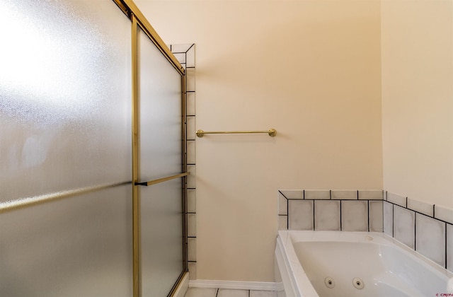 bathroom with tile patterned floors and a tub