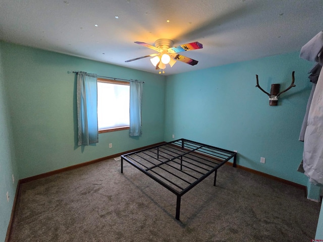 unfurnished bedroom featuring carpet flooring, a textured ceiling, and ceiling fan