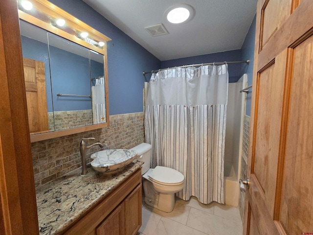 full bathroom with vanity, shower / tub combo, and toilet