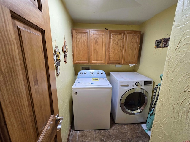 clothes washing area featuring cabinets and independent washer and dryer