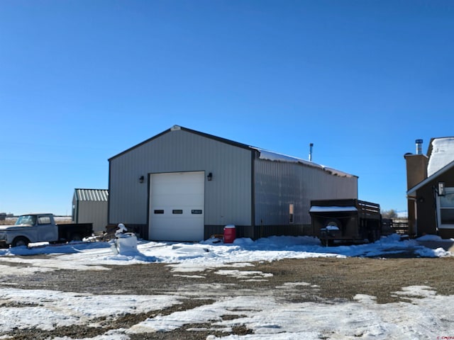 snow covered structure with a garage