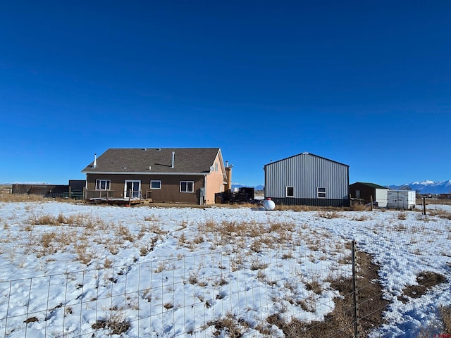 view of snow covered back of property