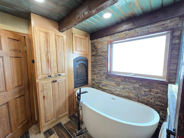 bathroom with beam ceiling, a bathtub, wooden ceiling, and hardwood / wood-style floors