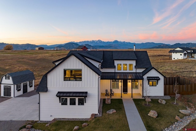 modern farmhouse style home featuring a mountain view, a yard, a storage unit, and a patio area