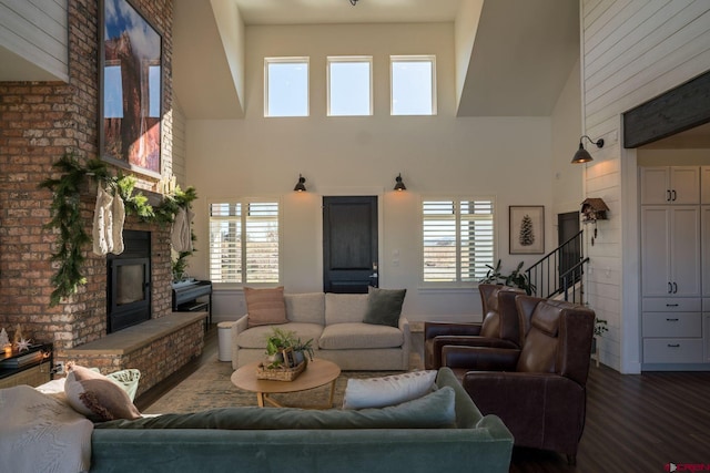 living room featuring hardwood / wood-style flooring, a fireplace, and a high ceiling