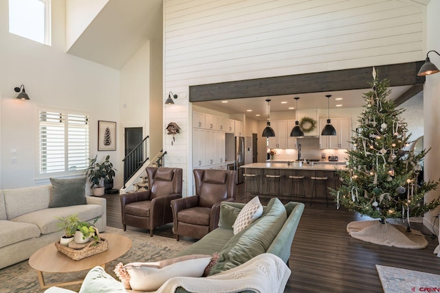 living room with hardwood / wood-style floors and a towering ceiling