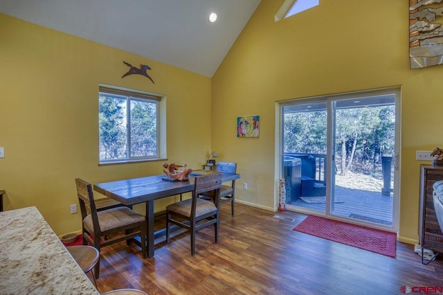 dining space featuring hardwood / wood-style floors and high vaulted ceiling