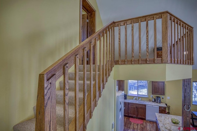 stairs featuring hardwood / wood-style floors and sink