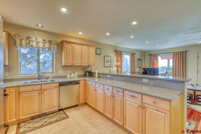 kitchen with dishwasher, sink, light brown cabinetry, light tile patterned flooring, and kitchen peninsula