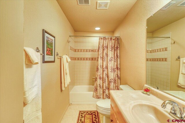 full bathroom featuring shower / bath combo, a textured ceiling, vanity, tile patterned flooring, and toilet