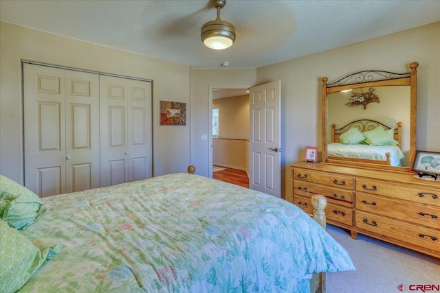 bedroom featuring carpet flooring, ceiling fan, a closet, and a textured ceiling