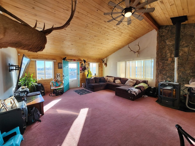 living room featuring lofted ceiling with beams, a wood stove, carpet floors, and wood ceiling