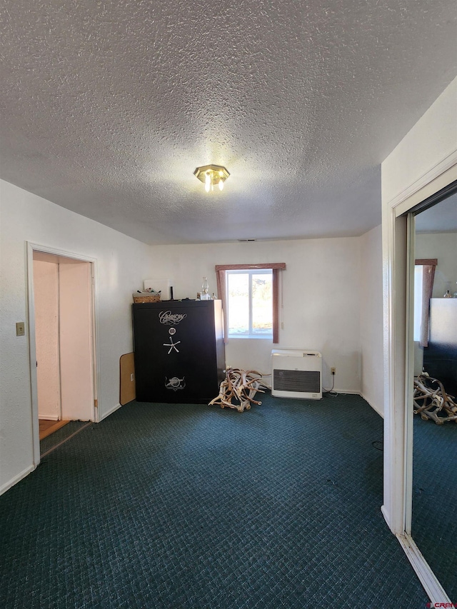 misc room with carpet, a textured ceiling, and heating unit