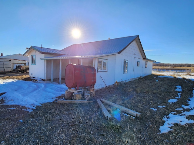 view of snow covered back of property