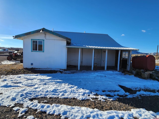 view of snow covered rear of property