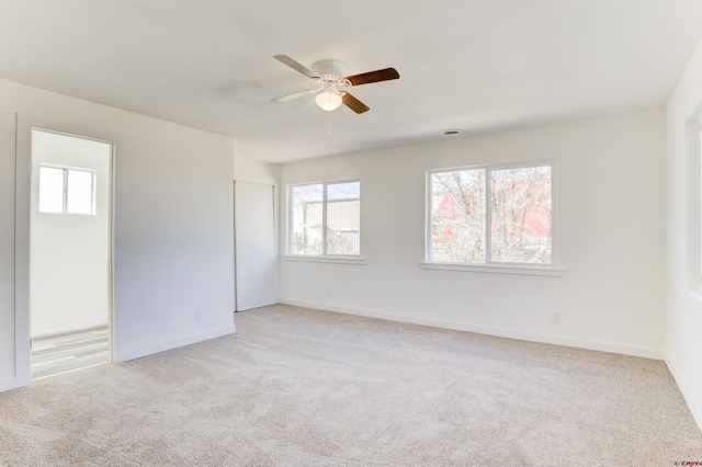 carpeted spare room featuring ceiling fan