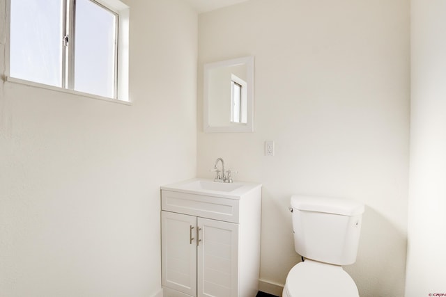 half bathroom with vanity and toilet