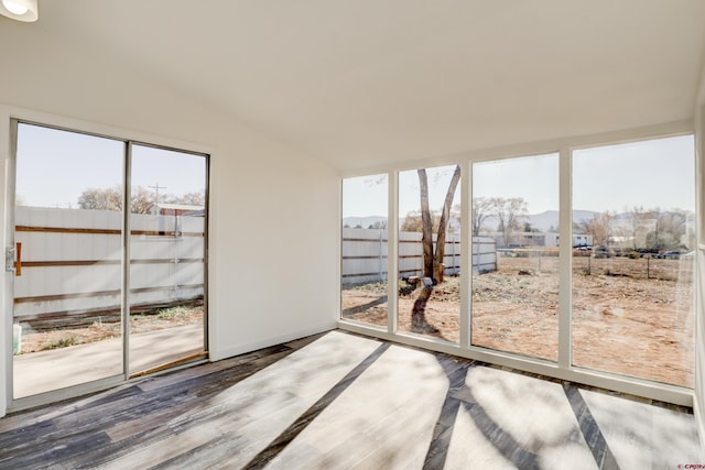 interior space featuring lofted ceiling, plenty of natural light, and wood finished floors