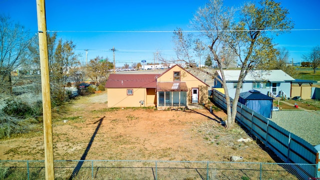 view of front of house featuring a fenced backyard, metal roof, dirt driveway, and stucco siding