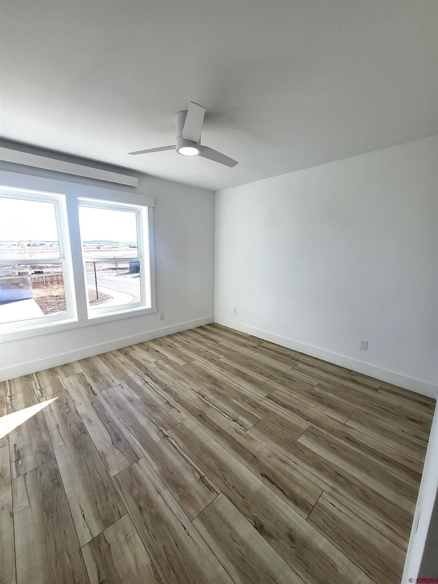 unfurnished room with ceiling fan and light wood-type flooring