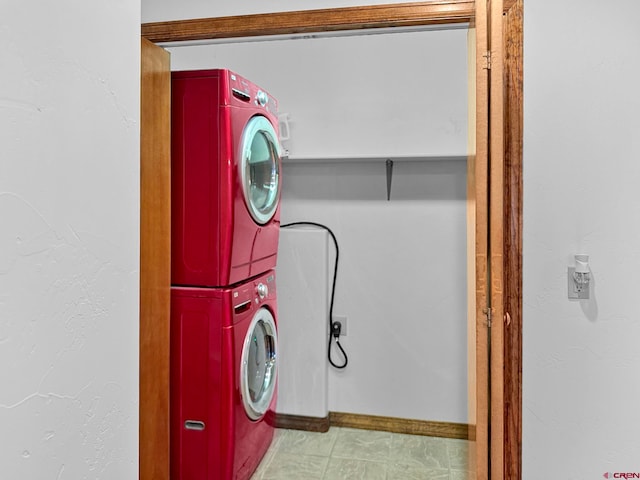 laundry area featuring light tile patterned floors and stacked washer and clothes dryer