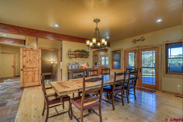 dining space featuring light hardwood / wood-style floors, french doors, beam ceiling, and an inviting chandelier