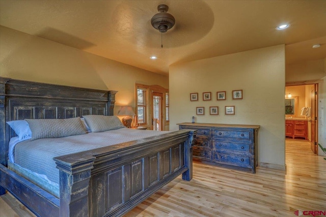 bedroom featuring ceiling fan, light wood-type flooring, and ensuite bathroom