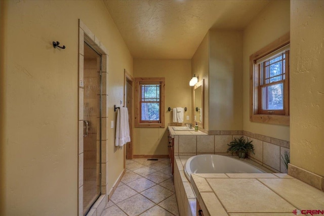 bathroom featuring vanity, a textured ceiling, tile patterned floors, and a healthy amount of sunlight