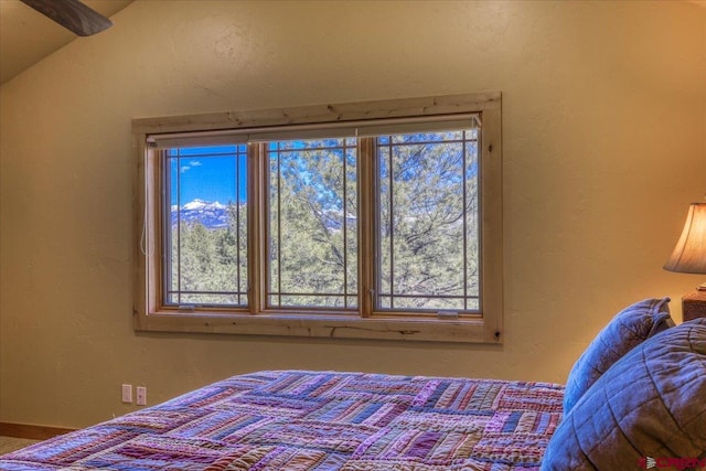 bedroom featuring multiple windows and lofted ceiling