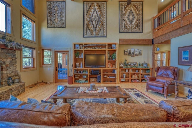 living room with wood-type flooring and a towering ceiling