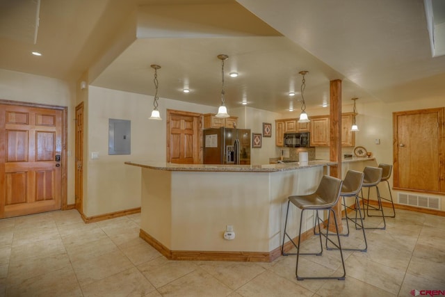 kitchen with a breakfast bar, decorative light fixtures, electric panel, black appliances, and light stone countertops