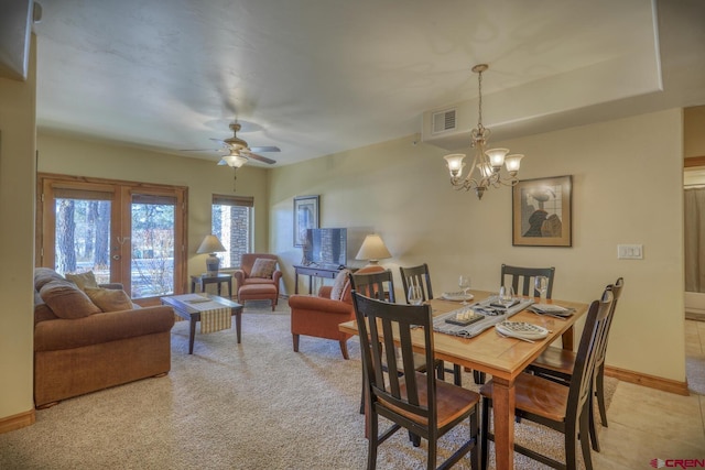 dining space with light carpet and ceiling fan with notable chandelier