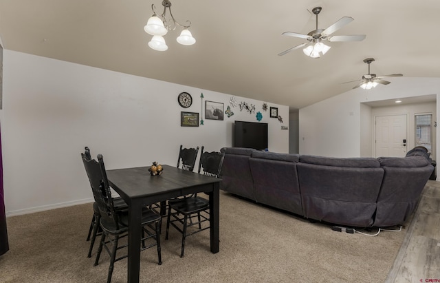 dining area featuring ceiling fan with notable chandelier, lofted ceiling, and hardwood / wood-style flooring