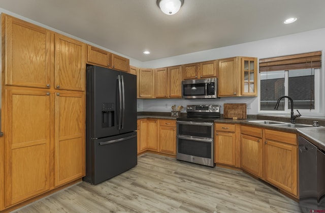 kitchen featuring sink, black appliances, and light wood-type flooring