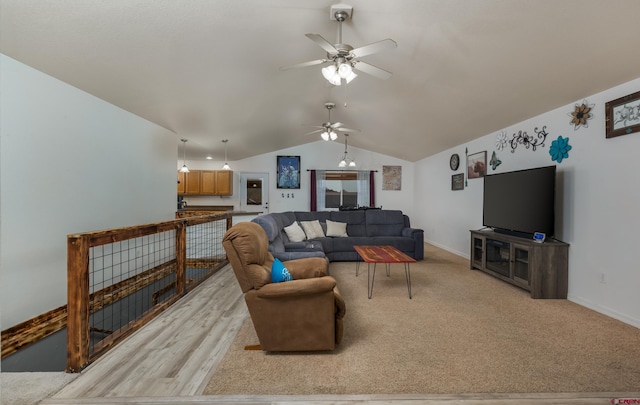 living room featuring ceiling fan, light wood-type flooring, and vaulted ceiling