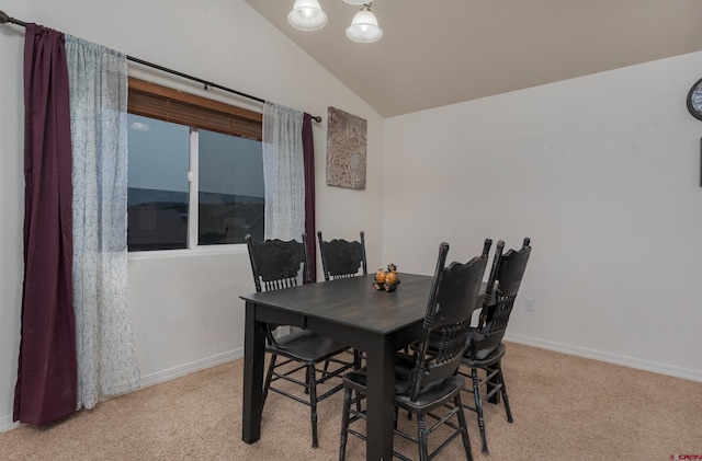 dining space featuring light colored carpet and vaulted ceiling