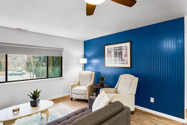 living area featuring hardwood / wood-style floors and ceiling fan