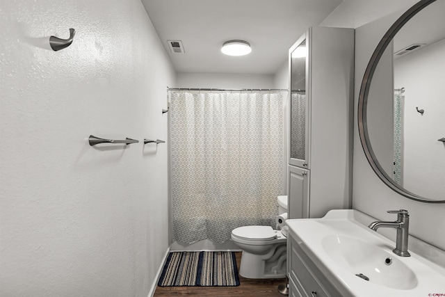 bathroom featuring wood-type flooring, toilet, and vanity